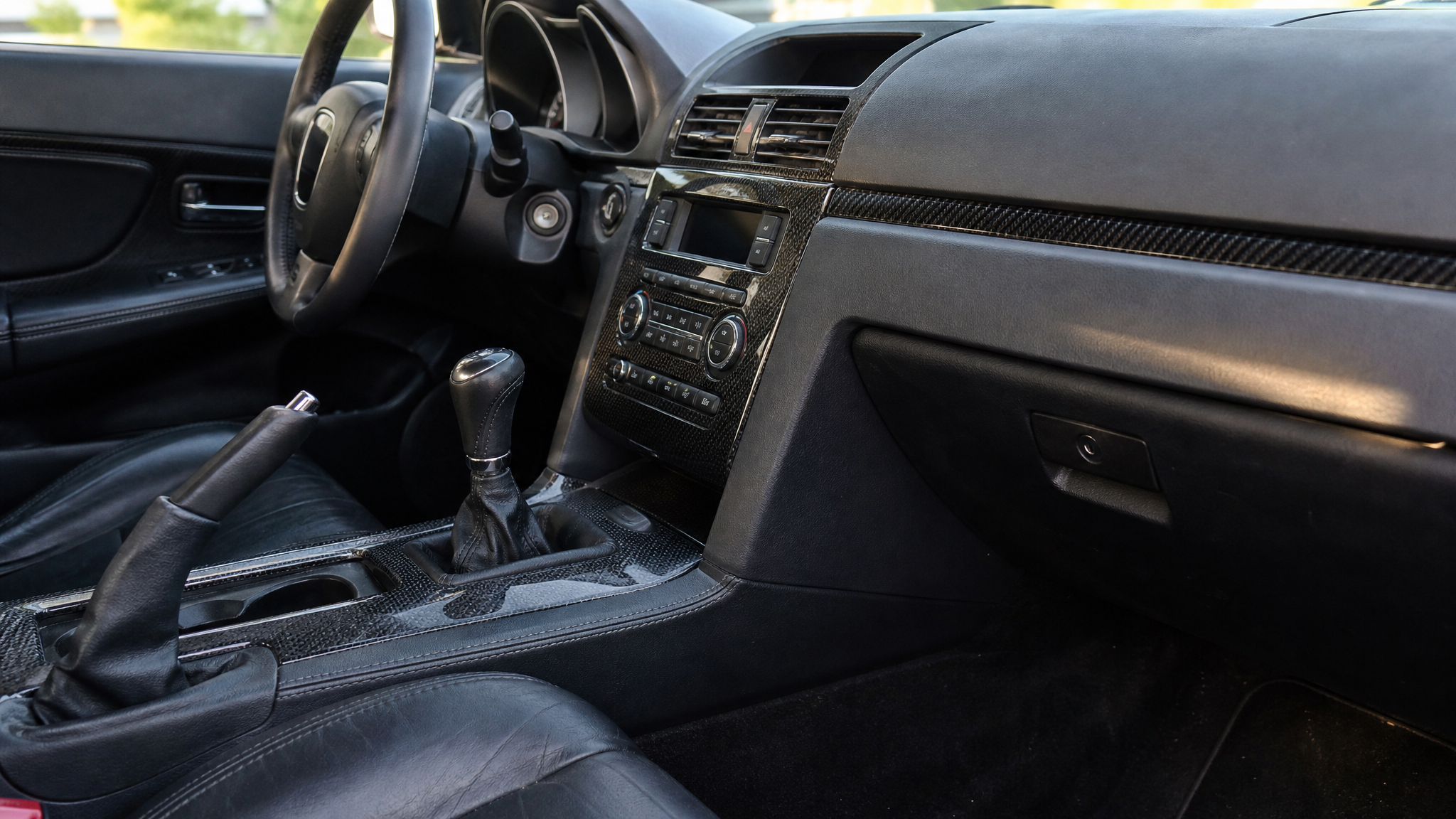 Carbon fiber vinyl wrapped center console and dashboard trim in a real car interior