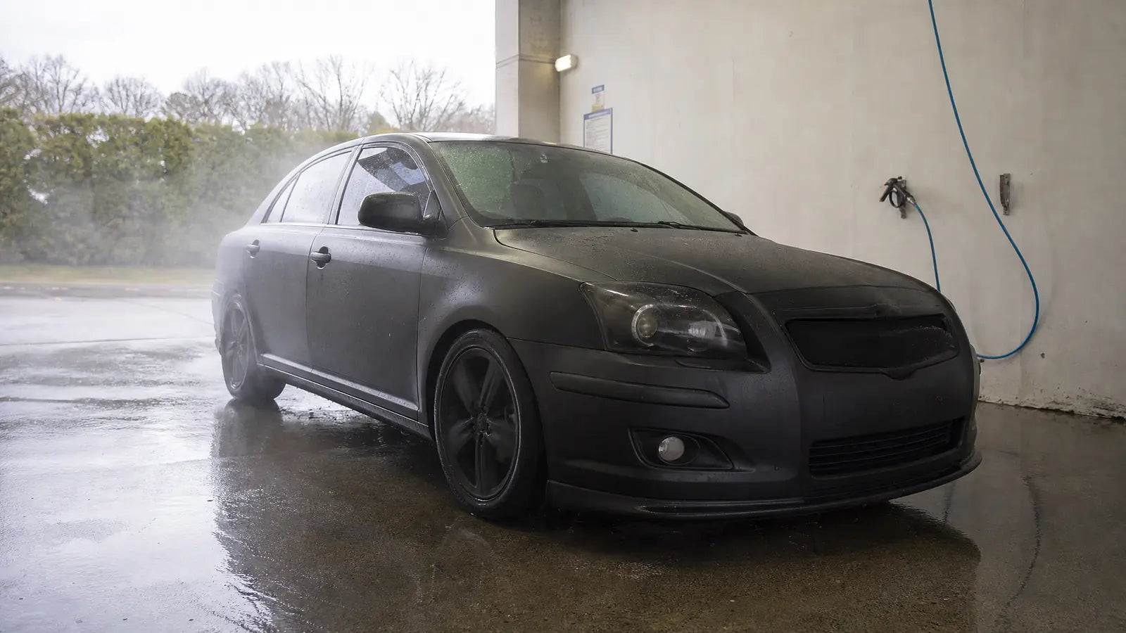 Wrapped car in a self serve wash bay for safe vinyl wrap cleaning