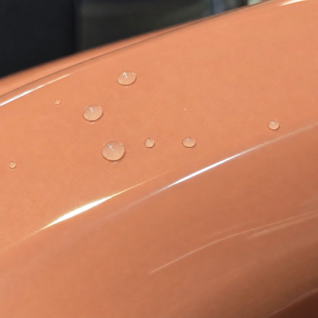 Close-up of Coral Orange gloss colored PPF surface texture | Veloro