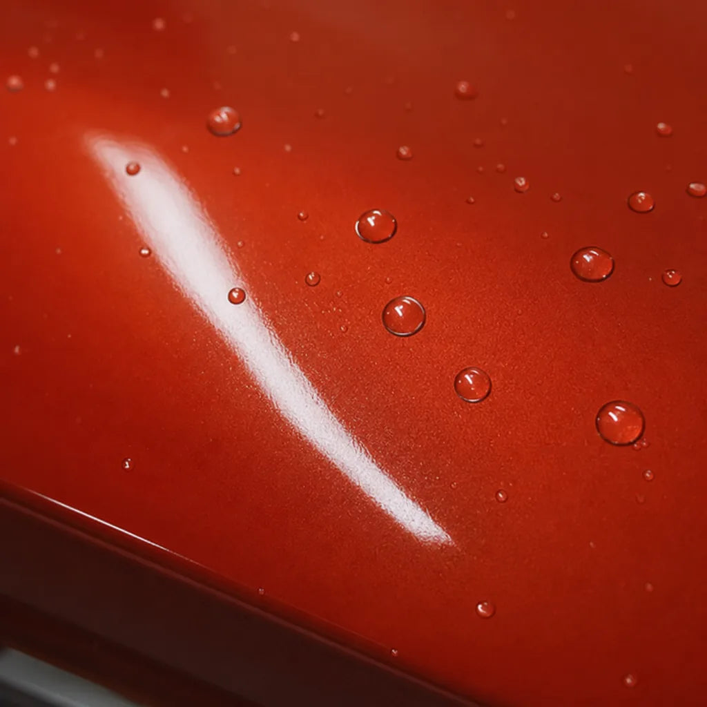 Close-up of Metallic Papaiya Orange gloss colored PPF surface texture | Veloro