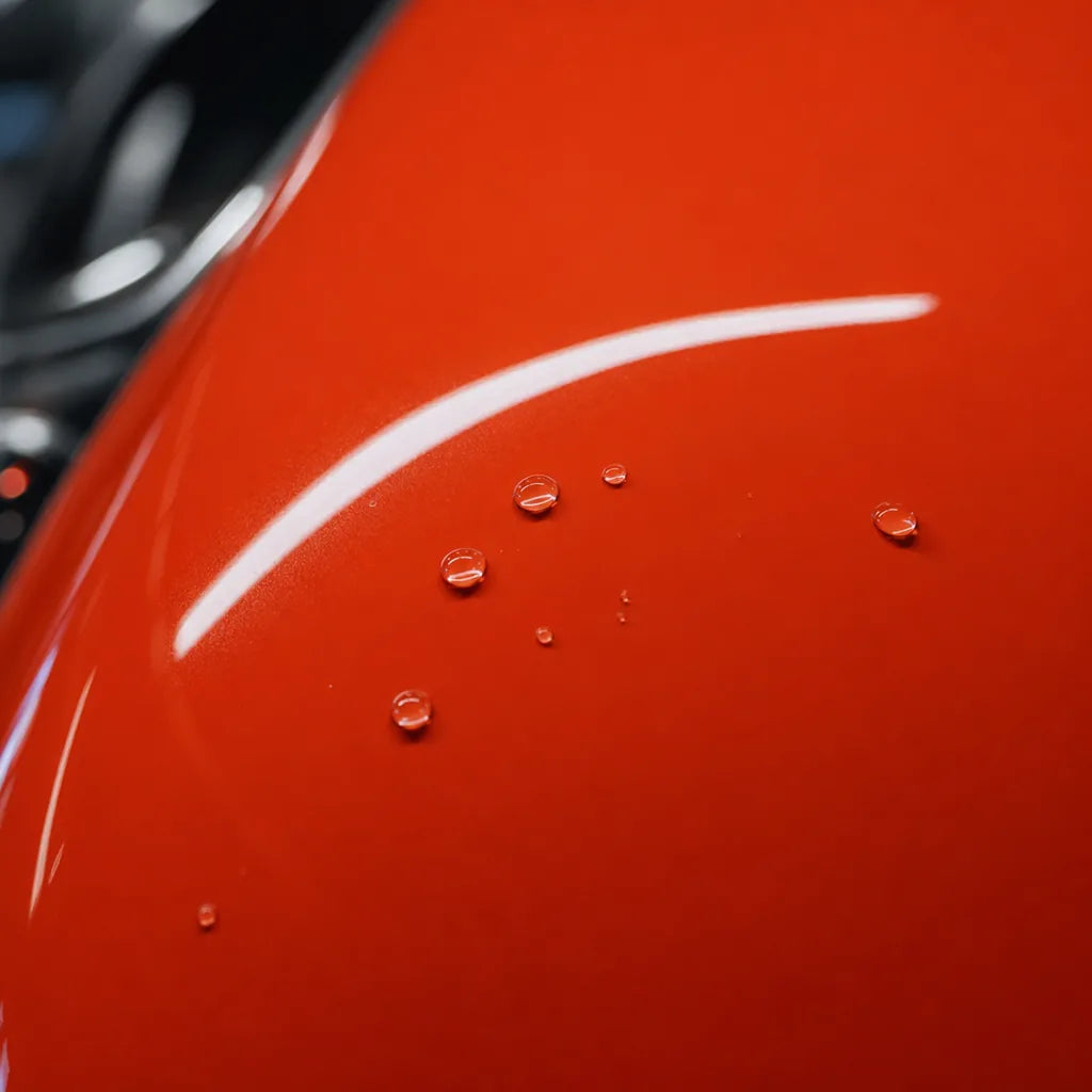 Close-up of Porsche Lava Orange gloss colored PPF surface texture | Veloro